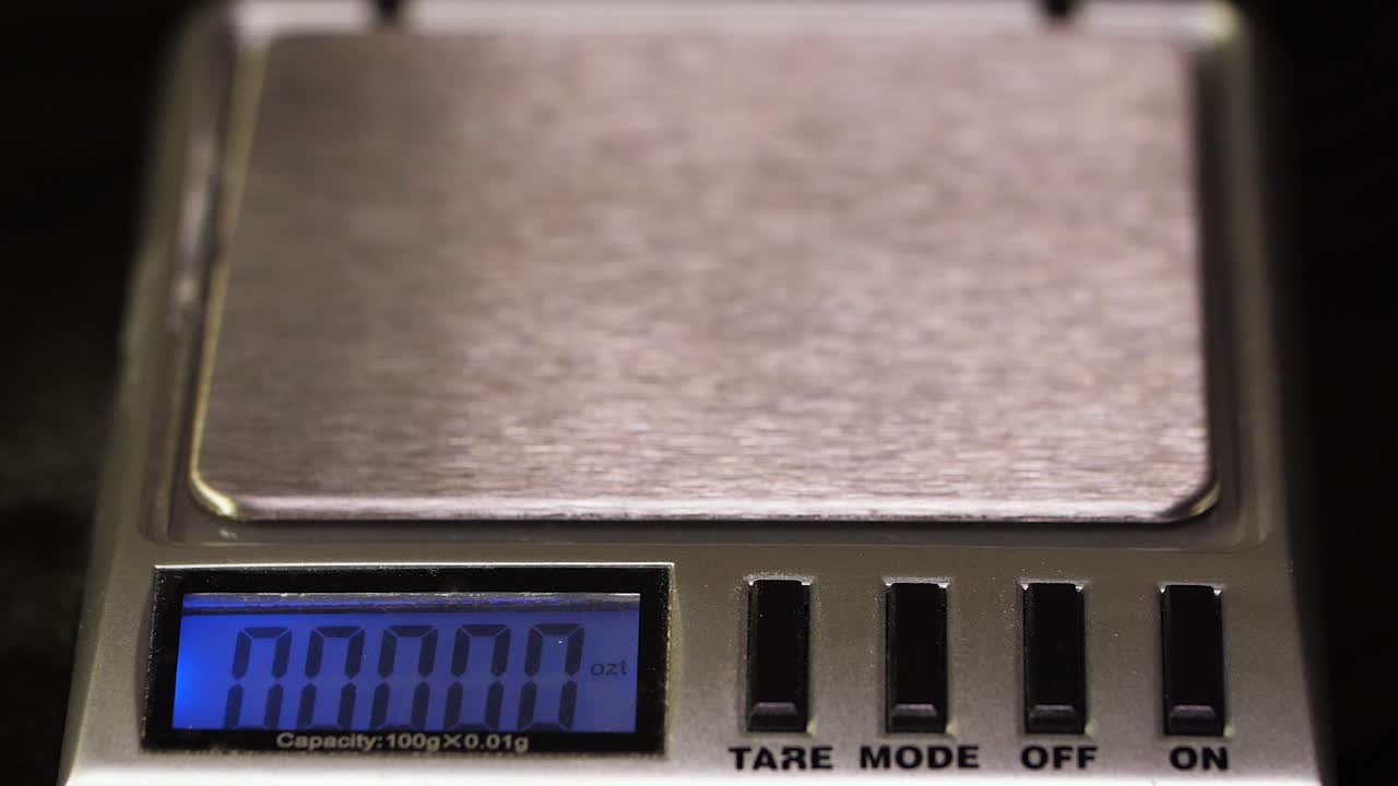 pesando una piedra preciosa de ónix negro en una balanza digital