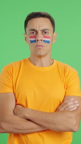 Dignified and serious man with dutch flag painted on face