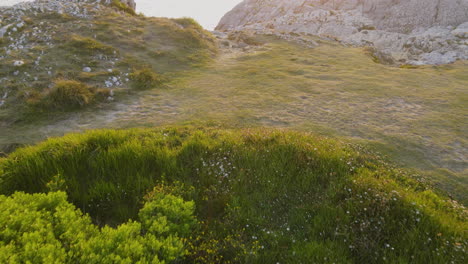 Luftaufnahme-Der-Felsigen-Küste,-Während-Eine-Gruppe-Von-Menschen-Die-Schöne-Landschaft-Einer-Klippe-Genießt