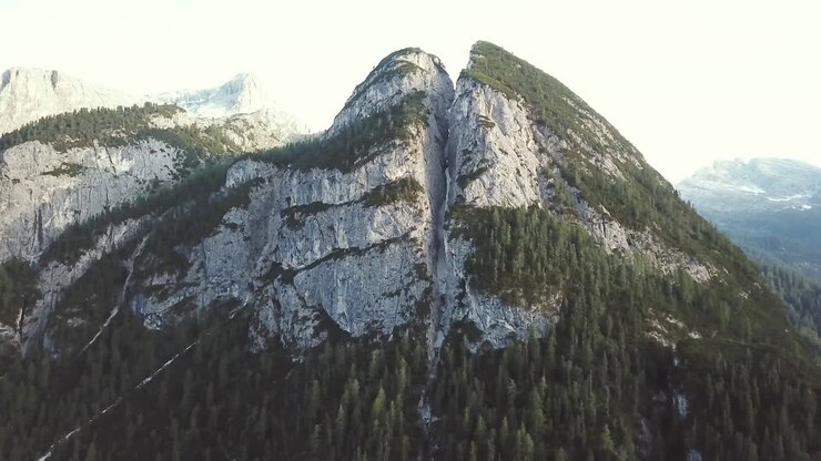 Schwenkende Luftaufnahme, die in den Alpen Berge und felsige Klippen enthüllt.