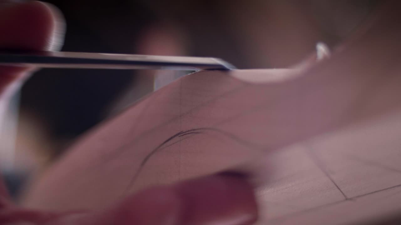 Skilled woodworker shaping a curved piece of timber using a metal hand tool in a workshop. Slow motion, detail view