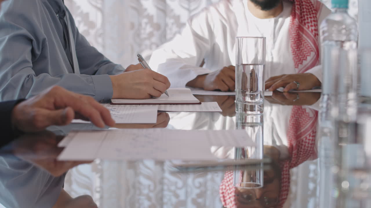Diverse Business Partners Negotiating And Signing Papers