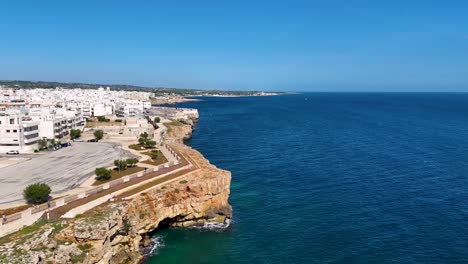 Aerial-Perspective-of-Polignano-A-Mare's-Rugged-Cliffs-and-Turquoise-Waters,-Italy