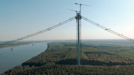 tower cranes erected by the bank of danube river during construction of braila bridge in romania