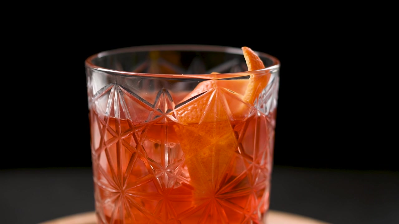 Cocktail Old Fashioned rotante su sfondo nero