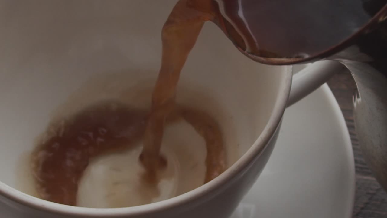 Steaming Coffee Being Poured from Cezve into White Cup