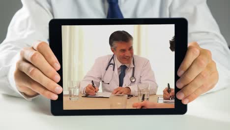 Doctor-holding-digital-tablet-and-having-discussion-in-meeting-4k