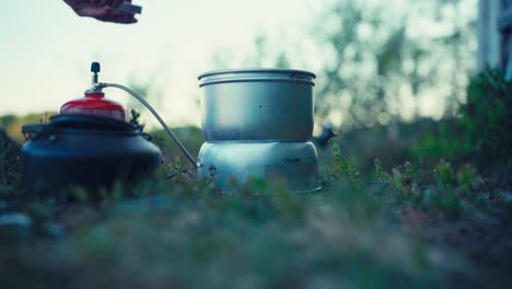 a man’s hands cooking on a portable stove while camping near imalitjønna in indre fosen, trøndelag, norway - close up