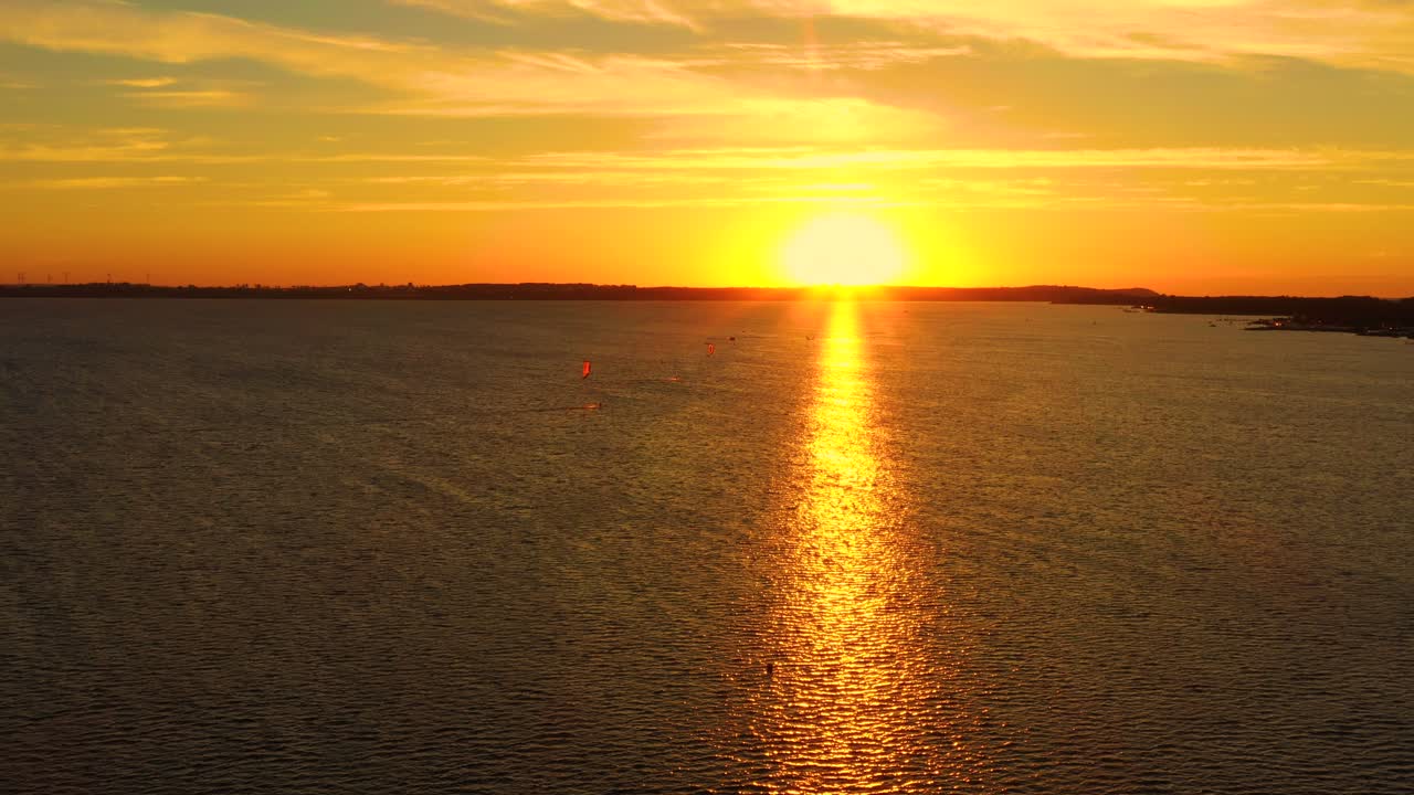 Aerial view, Kitesurfers swim at high speed in the open sea at sunset