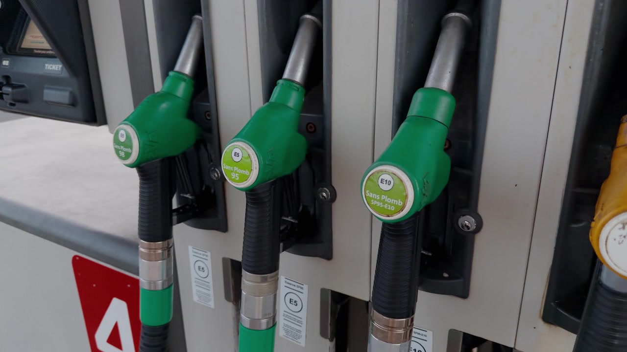 Vista dettagliata degli ugelli delle pompe di benzina in una stazione di servizio francese, che mostrano i tipi di carburante.