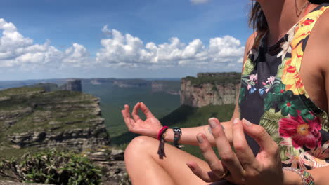 a girl meditating in a paradisic mountain with the view of the beautiful geological formation of chapada diamantina national park.