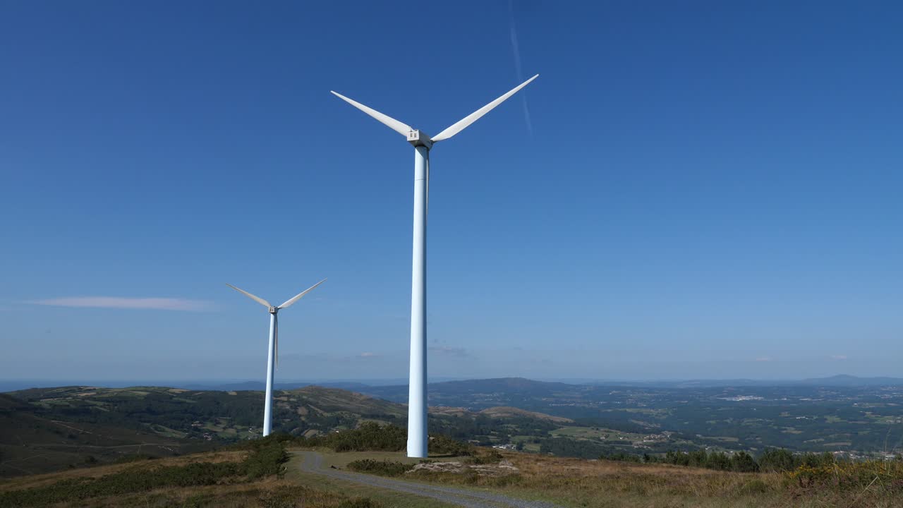 vista di una turbina eolica con un'enorme elica sulla cima di una collina