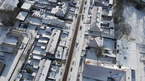 Antena-De-Carretera-Limpia-Que-Atraviesa-Un-Barrio-Suburbano-Cubierto-De-Nieve