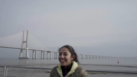 mujer morena sonriente entrenando en la orilla del mar
