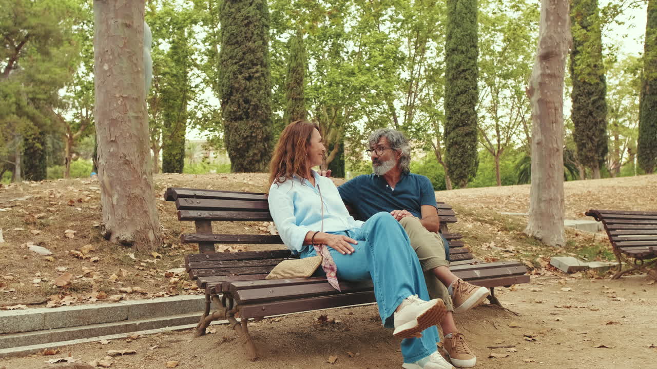 Happy Mature Couple Talking and Relaxing on Park Bench