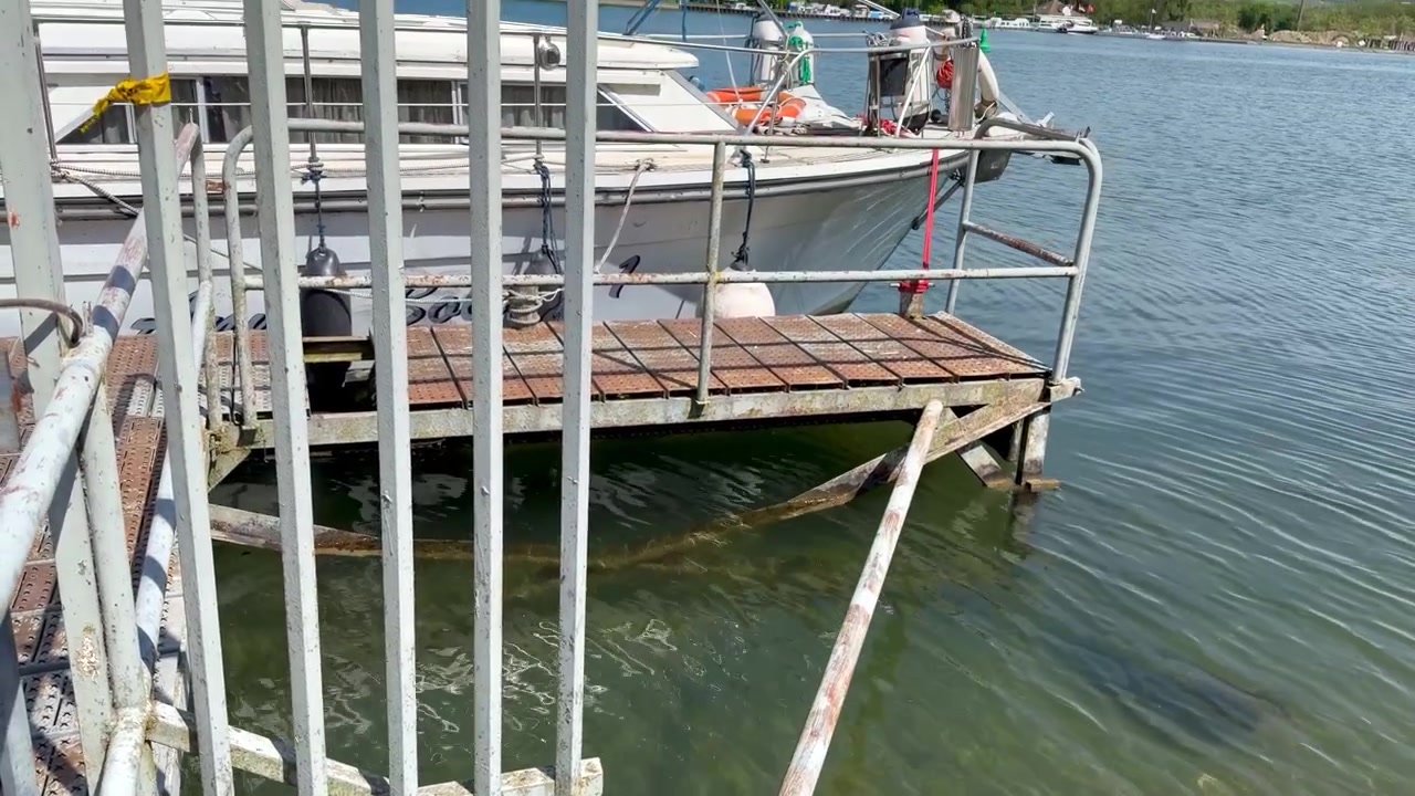 A yacht is moored on the banks of the Rhine; the path leading to the yacht is blocked off