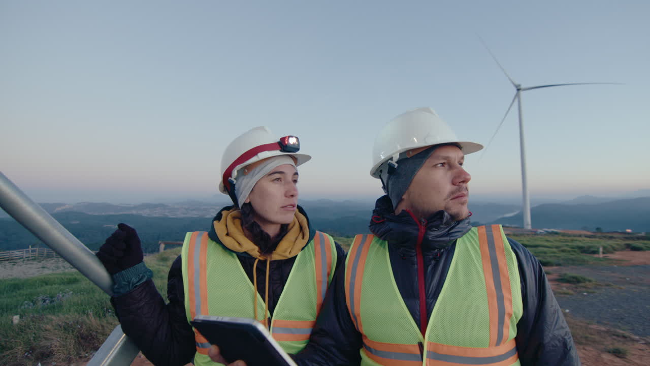 Technicians Working with Tablet and Speaking at Wind Power Plant