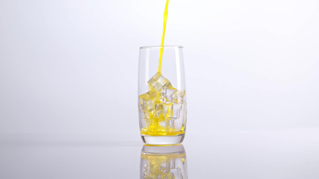 Pouring Orange Juice into a Glass with Ice