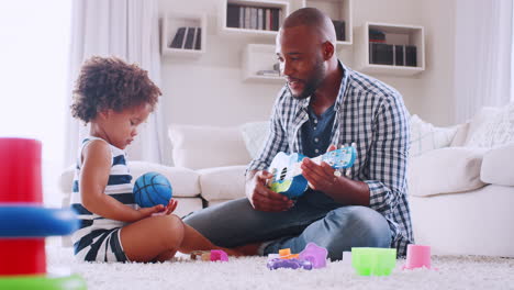 Papá-Negro-Joven-Jugando-Con-Su-Hija-Pequeña-En-La-Sala-De-Estar