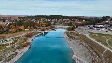 drone footage captures lake tekapo's vibrant autumn colors and serene waters, highlighting the church of the good shepherd