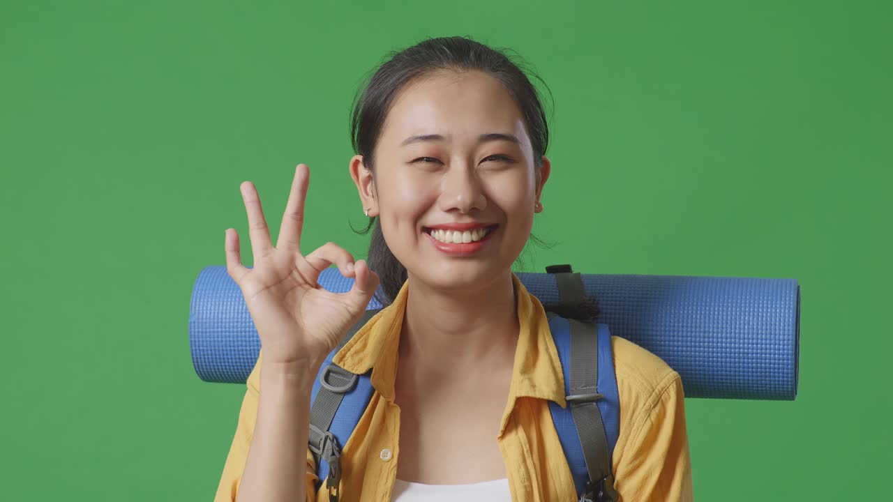 배 을 들고 있는 여자 가 ok 신호 를 내린다