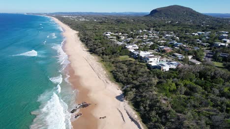 waves onto golden sand of yaroomba beach in the sunshine coast region, qld australia