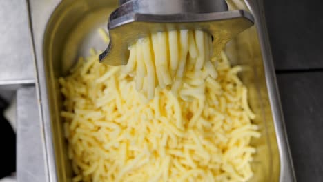 preparation of filling for dumplings, boiled potatoes are ground in a meat grinder