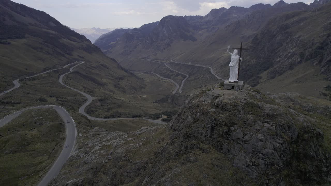 Veduta aerea della statua del Cristo Redentore delle Ande e della tortuosa strada di montagna.