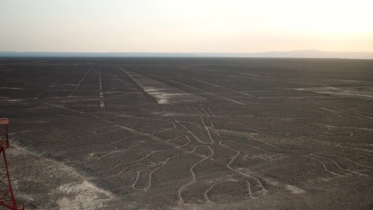 Desert geoglyphs and etched terrain across Nazca Lines plateau in Peru, panoramic overview out to sweeping horizon
