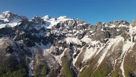 Hohe-Gipfel-Der-Alpinen-Berge,-Die-Von-Weißem-Schnee-Unter-Dem-Blauen-Himmel-In-Albanien-Bedeckt-Sind