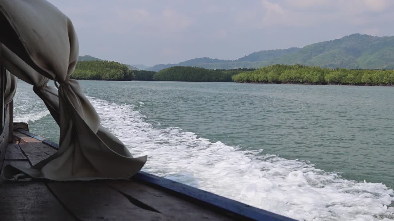Experience a boat ride with views of lush green shores and gentle waves.