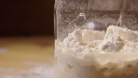 slow motion close up, sourdough starter is mixed with spoon