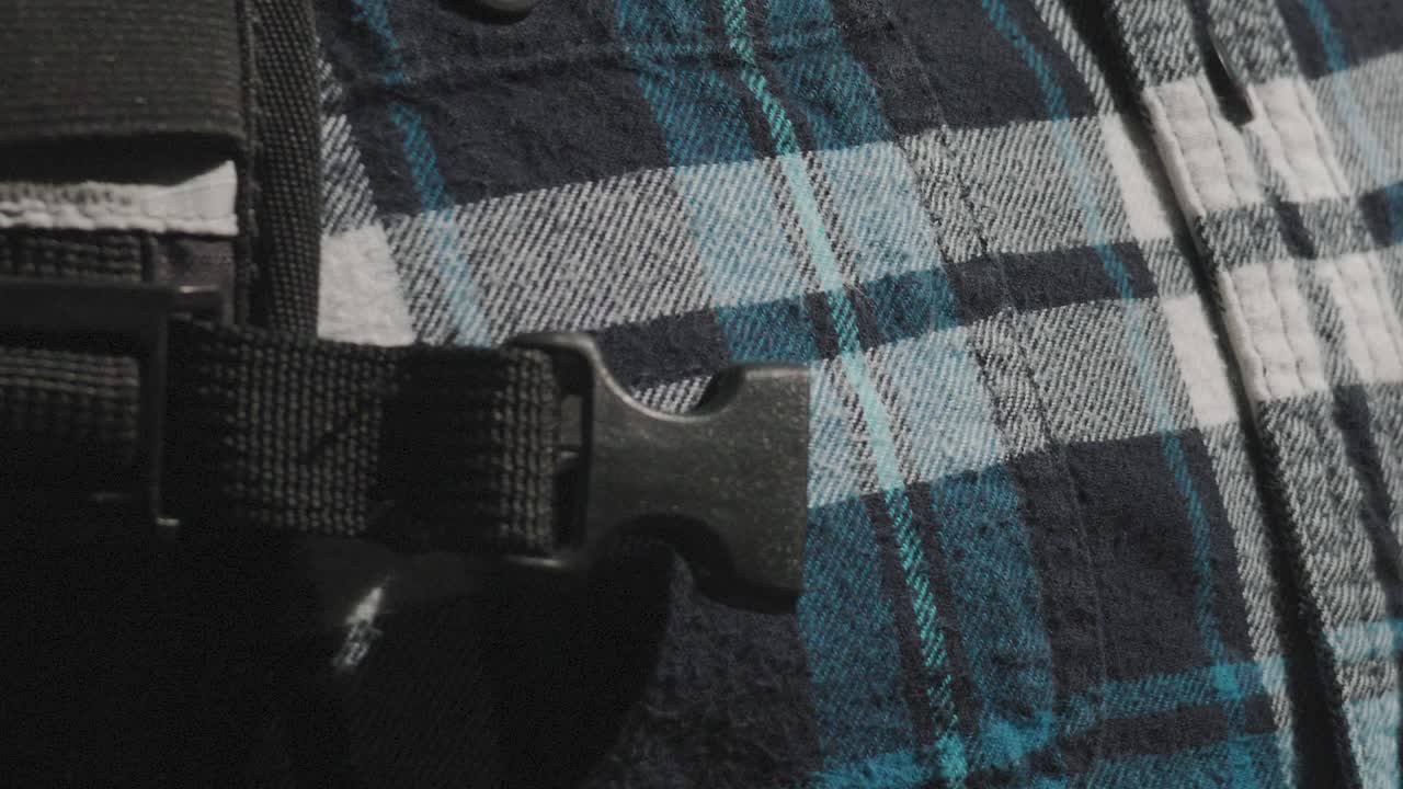 Hands clipping tightening chest buckle from hiking outdoor backpack close up