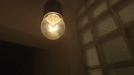 bombilla colgante en una habitación con una ventana