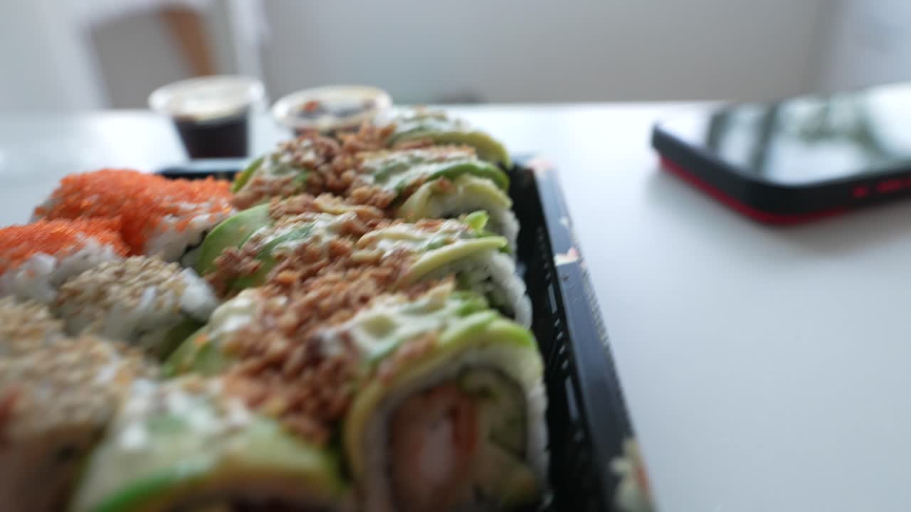 Çubuklarla Lezzetli Suşi ve Japon Paket Yemeği Yiyen Kişi