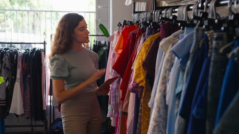 propietaria o trabajadora de una tienda de ropa de moda comprobando el stock con una tableta digital