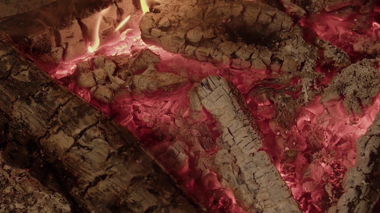 vista de cerca: brasas rojas, carbón caliente en el fuego del campamento quemado por la noche