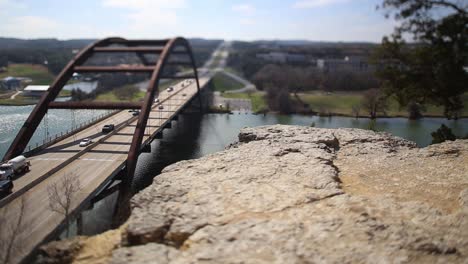 austin pennybacker bridge tilt-shifted time-lapse, focus isolates section of ledge and front part of the bridge. heavy traffic flow northbound and traffic backs up once light changes.