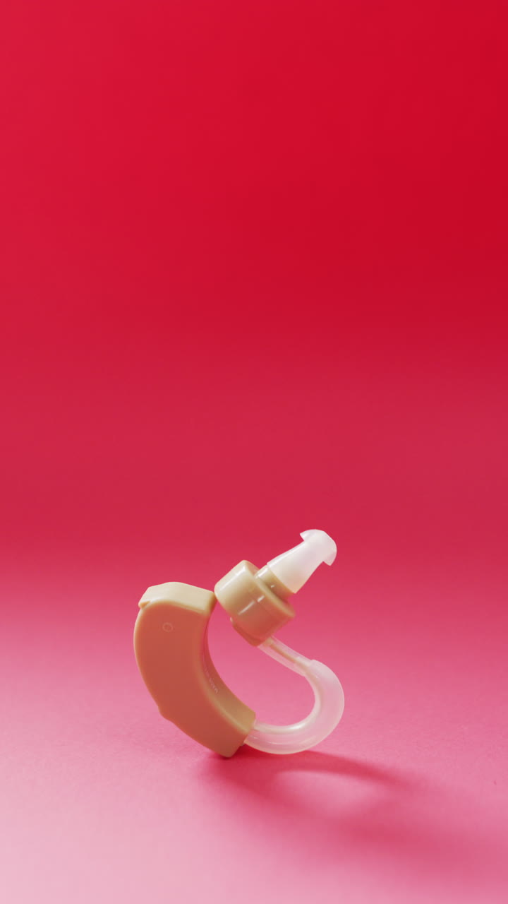 vídeo vertical del audífono sobre fondo rojo, con espacio para copiar