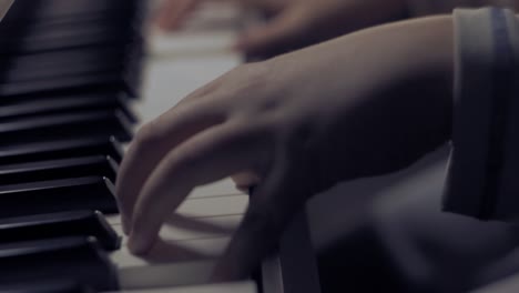 Young-boy-playing-piano,-close-up-of-hands-ending-a-musical-piece