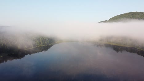 See-Am-Frühen-Morgen-Mit-Tief-Hängenden,-Nebligen-Wolken-Im-Abgelegenen-Bergwald