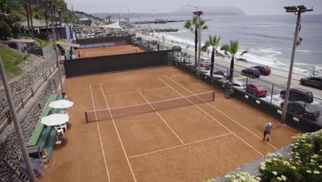 tiro inclinado hacia arriba de canchas de tenis de lado a lado cerca del impresionante paisaje marino, perú