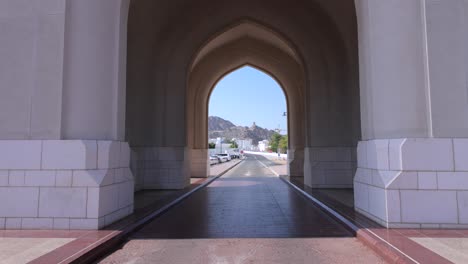 walking through an archway in old muscat, oman at an historic castle fort tower on the mountain