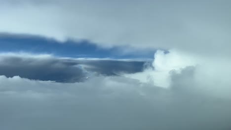 un tiro impresionante desde una cabina de un avión mientras vuela entre nubes de tormenta evitando el mal tiempo y buscando una brecha para cruzar las nubes