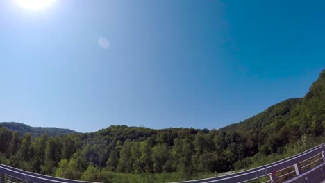 driving through a scenic mountain valley on a sunny day