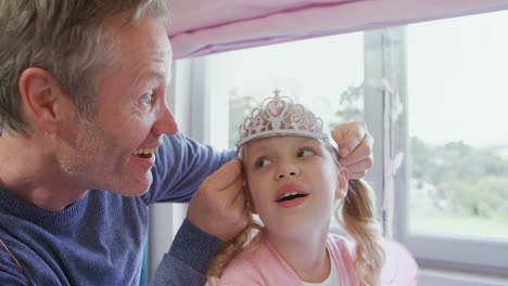 father placing tiara over daughters head 4k