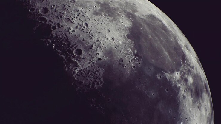 Vista majestosa da lua exibindo crateras e texturas sob um céu estrelado.
