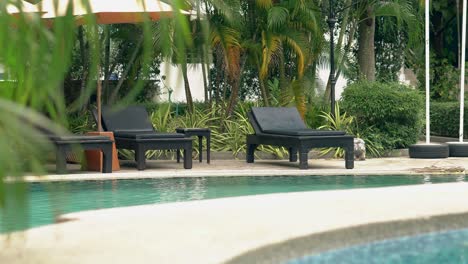 exciting-black-wooden-loungers-stand-near-swimming-pools