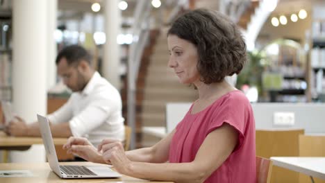 Side-view-of-pensive-Caucasian-woman-using-laptop