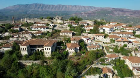 White-Houses-with-Thousand-Windows-of-Berat's-Amazing-Beauty,-Hilltop-Majesty,-and-Stunning-Mountain-Backdrop,-a-Top-Tourist-Destination